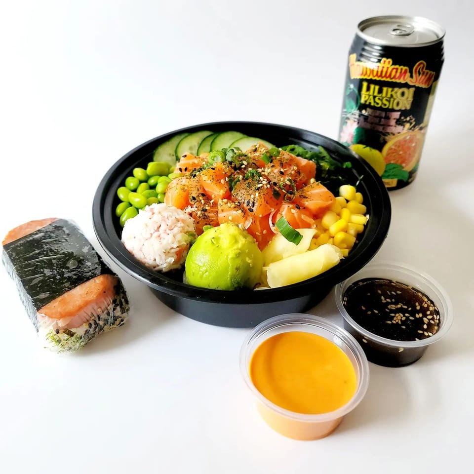 Oh Poke bowl with salmon, avocado, edamame, corn, and rice, with a Spam musubi and drink.