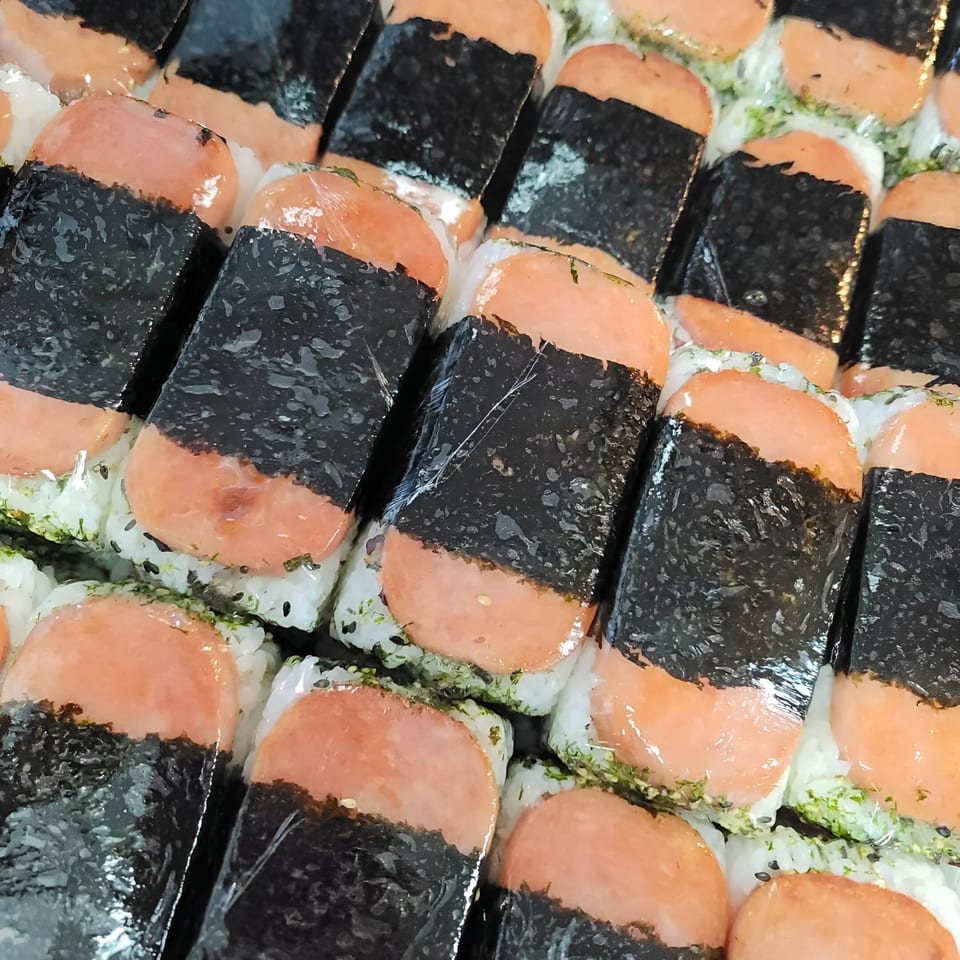 Rows of individually wrapped Spam musubi, featuring grilled Spam, rice, and nori, from Oh Poke.